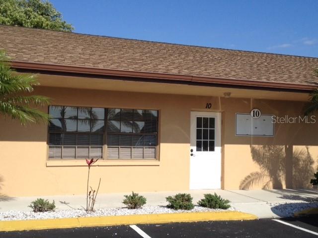 A tan, single-story commercial building exterior features a white door labeled 10 and a window — 13910 FIVAY ROAD UNIT 10, HUDSON, FL