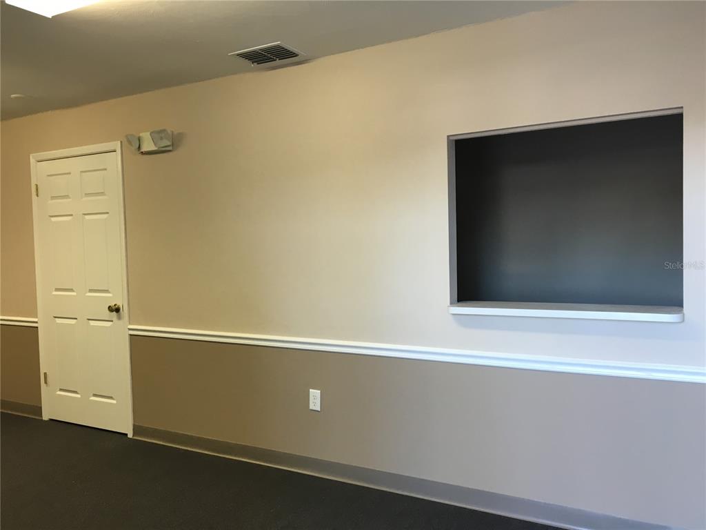 An interior room features a white door, a dark wall cutout, and two-toned walls — 13910 FIVAY ROAD UNIT 10, HUDSON, FL