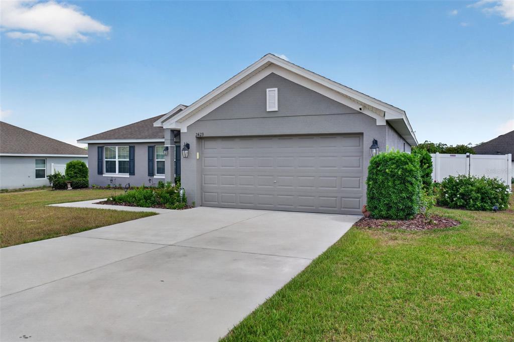 A gray single-story house with a two-car garage and a concrete driveway — 2429 TWIN LAKE VIEW ROAD, WINTER HAVEN, FL