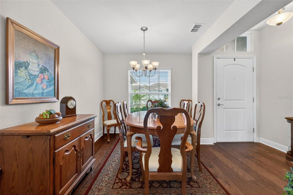 A dining room features a wooden table with chairs, a sideboard, and a chandelier — 2429 TWIN LAKE VIEW ROAD, WINTER HAVEN, FL