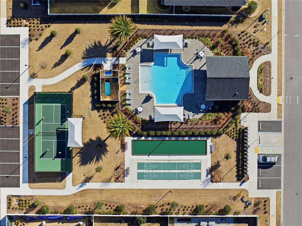 Aerial view of a community recreation area featuring a swimming pool, tennis court, and courts — 7561 SW 76TH TERRACE, OCALA, FL