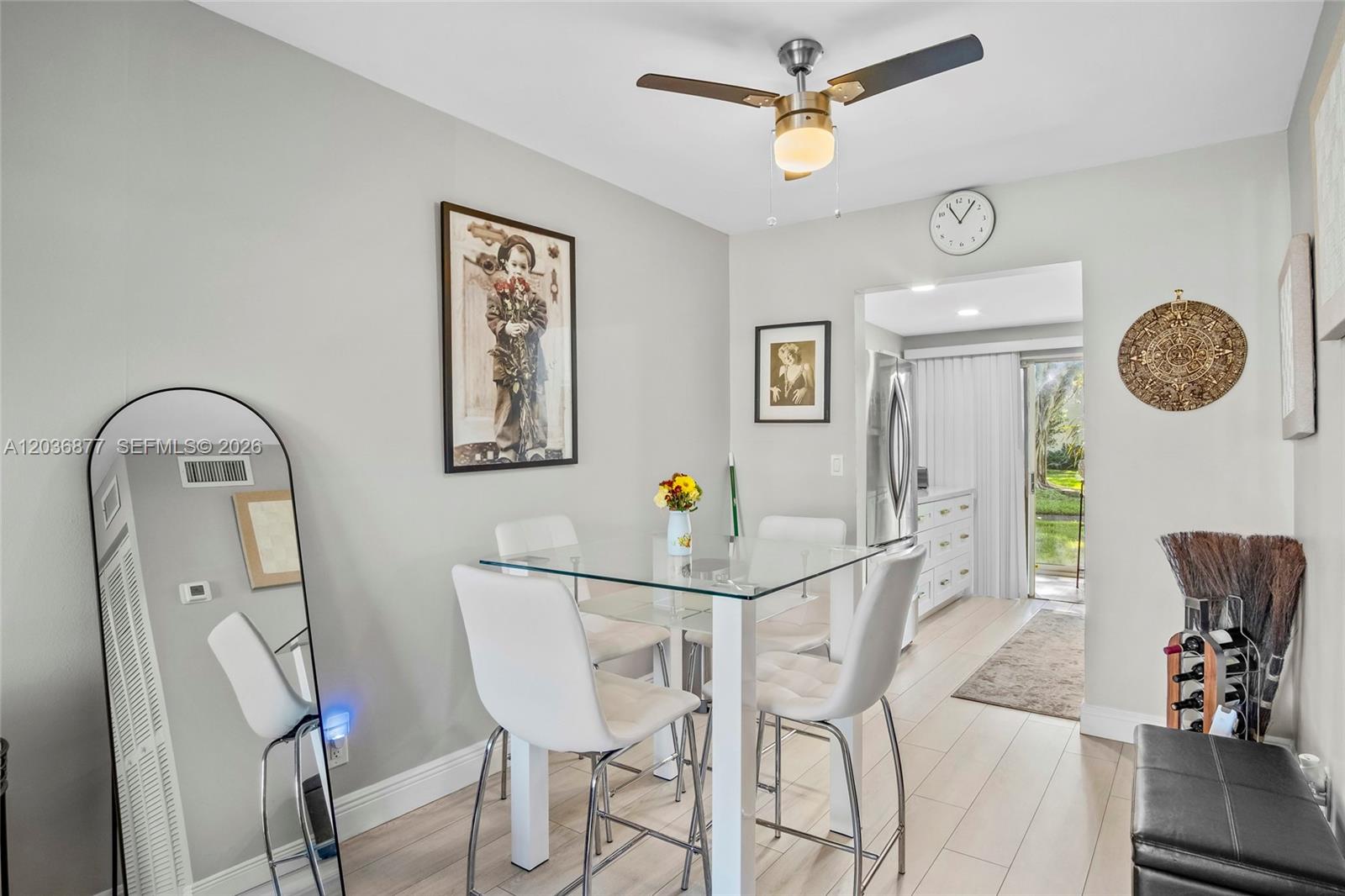 A dining area features a glass-topped table, four white chairs, and a ceiling fan — 19 Abbey Ln # 104, Delray Beach FL 33446, DELRAY BEACH, FL
