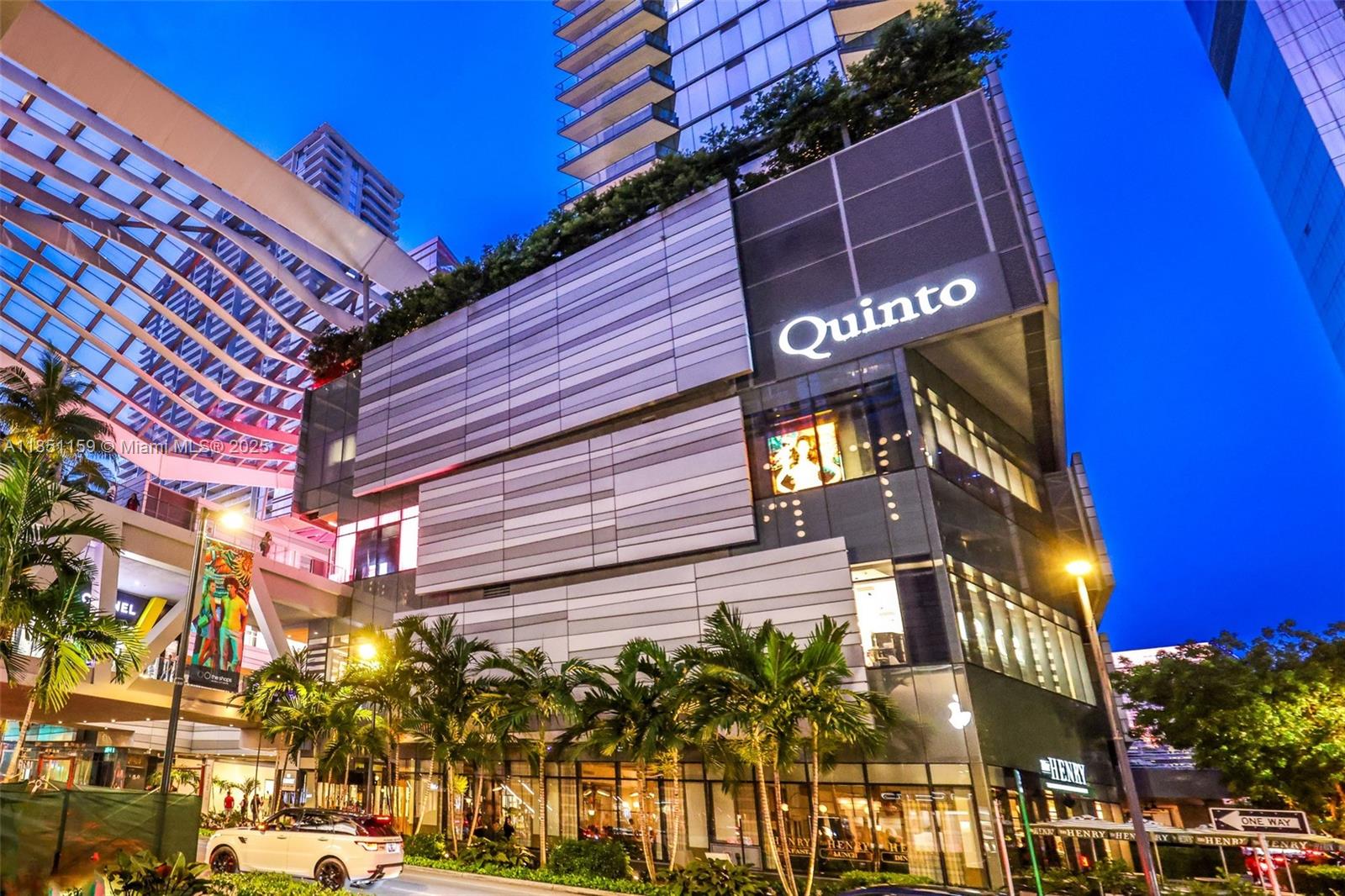 A modern multi-story building features a Quinto restaurant sign and palm trees at street level — 55 SW 9th St # 3906, Miami FL 33130, MIAMI, FL