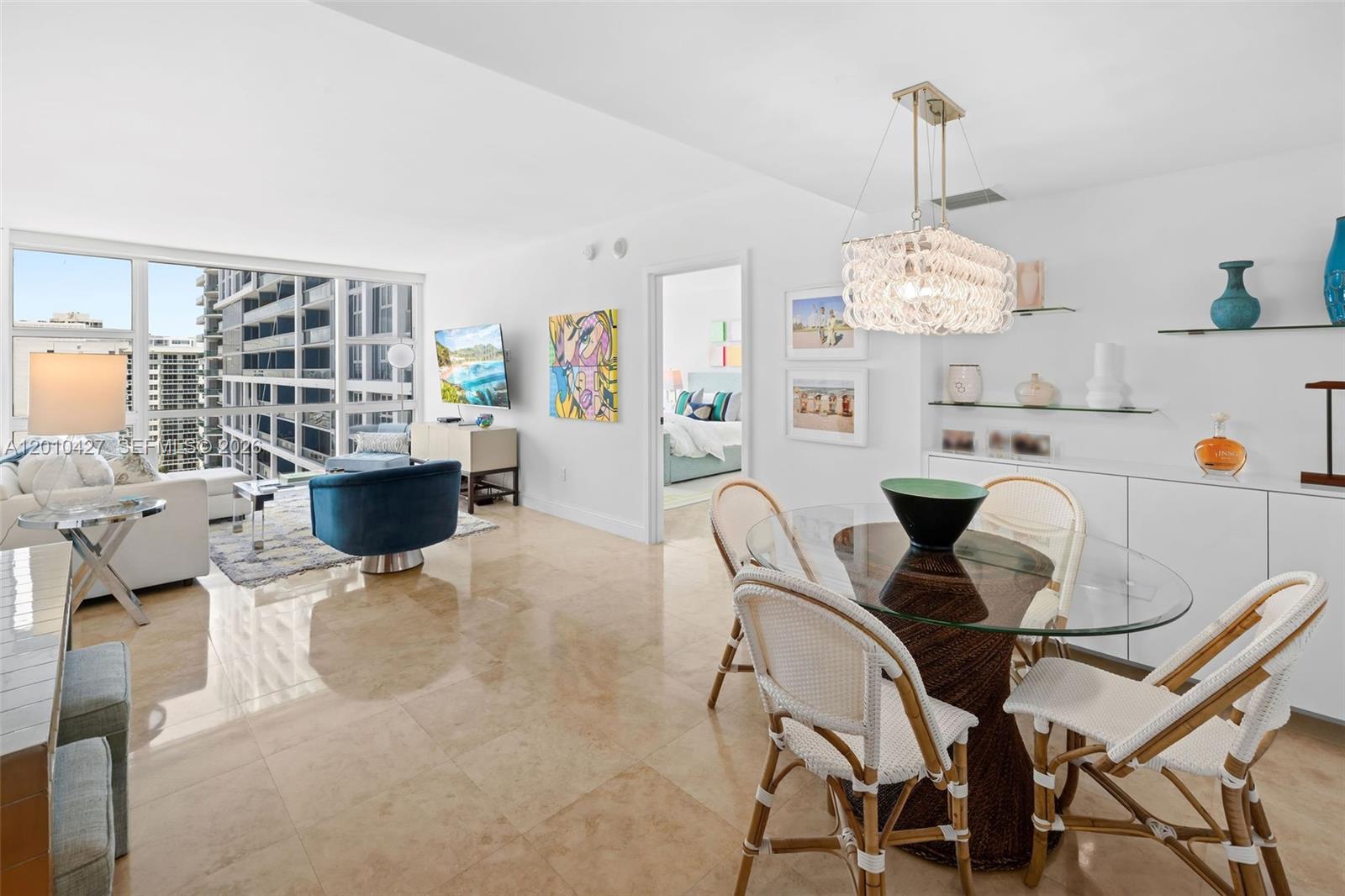 A bright living and dining area features tile floors, a glass table, and city views — 6801 Collins Ave # 1215, Miami Beach FL 33141, MIAMI BEACH, FL