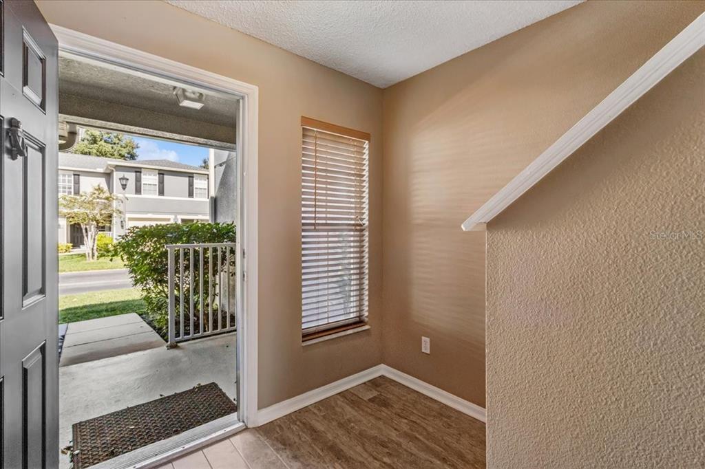 An entryway with wood-look flooring, a window with blinds, and a view of the outdoors — 13054 LEXINGTON SUMMIT STREET, ORLANDO, FL