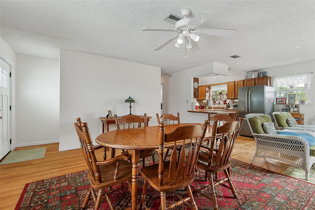 A dining area with a wooden table and chairs sits on a patterned rug — 309 CYPRESS STREET, FLAGLER BEACH, FL