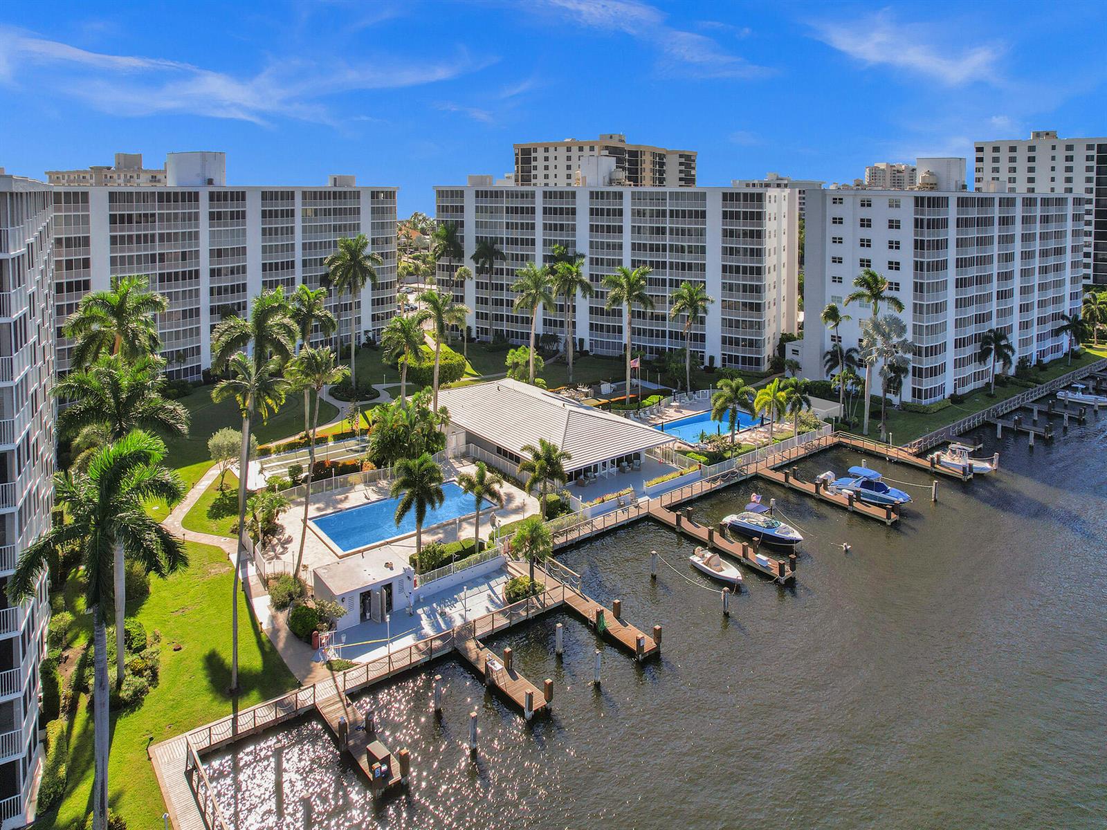 An aerial view of a waterfront apartment complex featuring a swimming pool and private boat docks — 3310 S Ocean Boulevard # d, Highland Beach FL 33487, HIGHLAND BEACH, FL