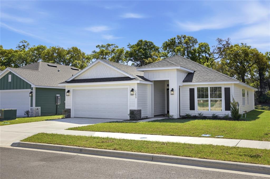 A single-story house with white siding, a two-car garage, and a front-facing gable roof — 2590 SW 250TH TERRACE, NEWBERRY, FL