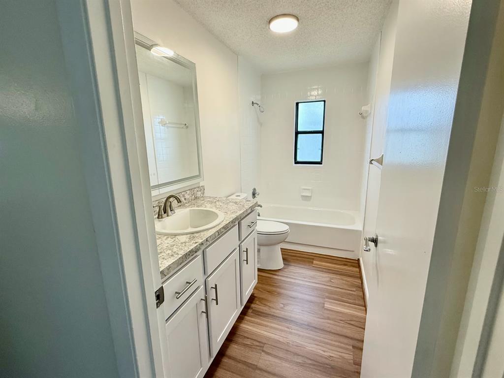 A bathroom features a white vanity with a stone countertop, a toilet, and a bathtub — 6862 SE 52 PLACE, OCALA, FL