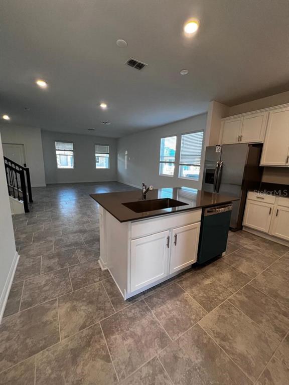A kitchen island with a dark countertop sits in a room with tile flooring — 4134 PINO STREET, APOPKA, FL