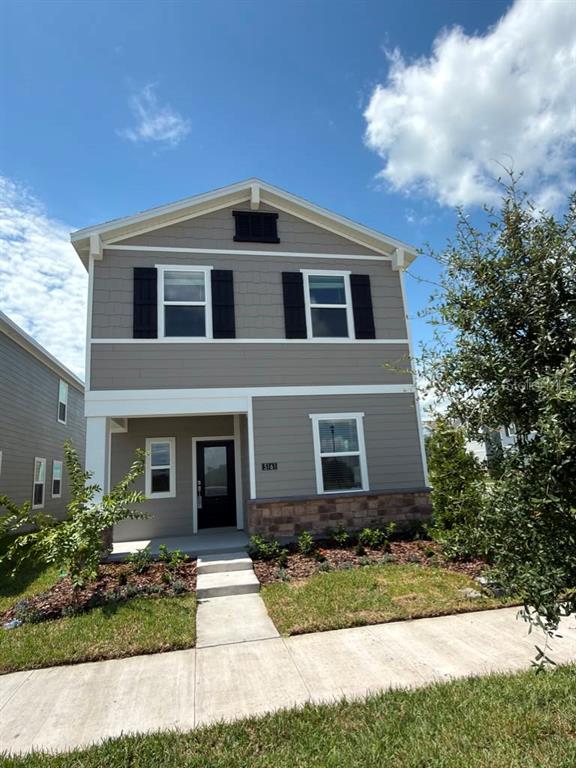 A two-story house with gray siding, stone accents, and a covered front porch — 5161 MARLBERRY COURT, ST CLOUD, FL