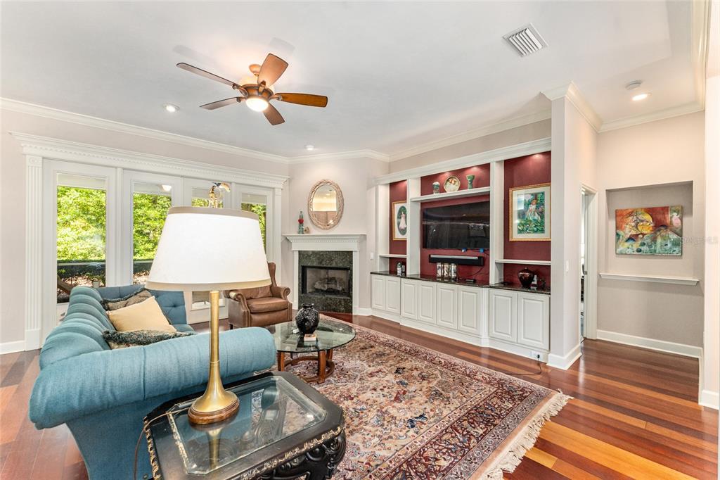 A living room features a blue sofa, fireplace, built-in shelving, and hardwood floors — 6415 SW 88TH TERRACE, GAINESVILLE, FL