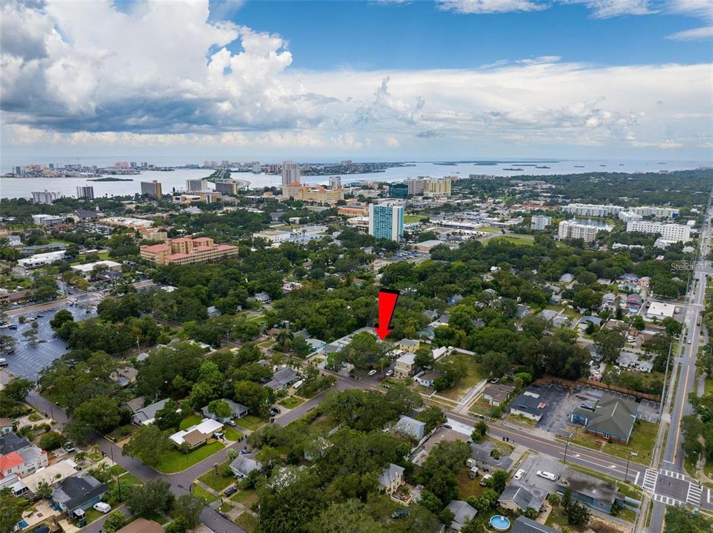 An aerial view shows a residential neighborhood with a red arrow pointing to a property — 912 DRUID ROAD E, CLEARWATER, FL