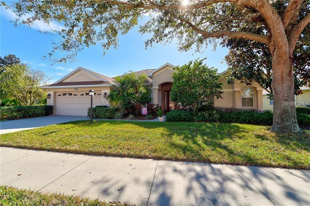A single-story house with a two-car garage and a large tree in the front yard — 13335 PURPLE FINCH CIRCLE, BRADENTON, FL