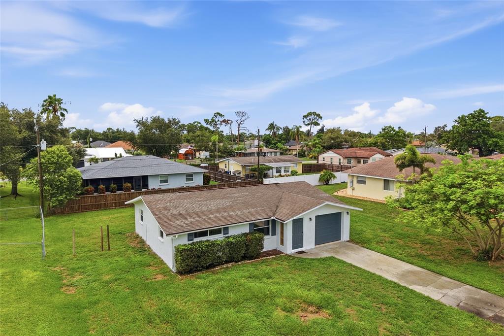 An aerial view of a single-story house with a brown roof and a concrete driveway — 935 EVEREST ROAD, VENICE, FL