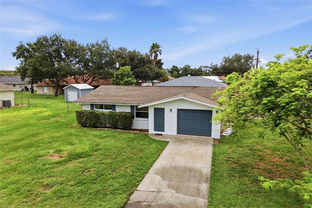 A single-story house with a white exterior, blue garage door, and a concrete driveway — 935 EVEREST ROAD, VENICE, FL
