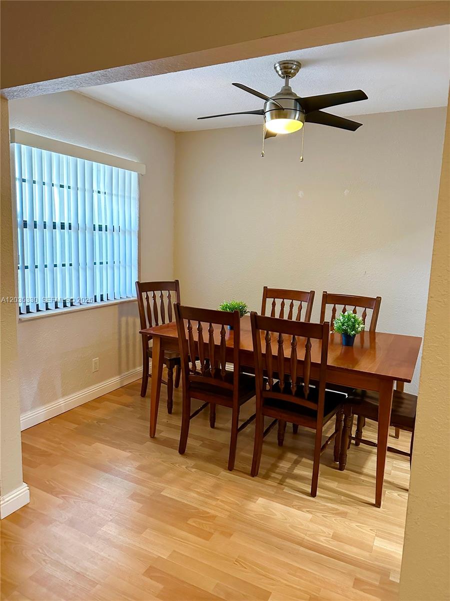 A dining room features a wooden table, four chairs, light wood flooring, and a ceiling fan — 500 NE 2nd St # 327, Dania Beach FL 33004, DANIA BEACH, FL