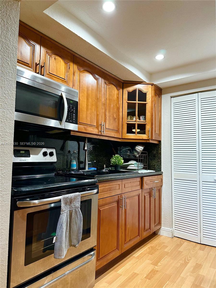 A kitchen features wood cabinets, stainless steel appliances, and a dark countertop — 500 NE 2nd St # 327, Dania Beach FL 33004, DANIA BEACH, FL