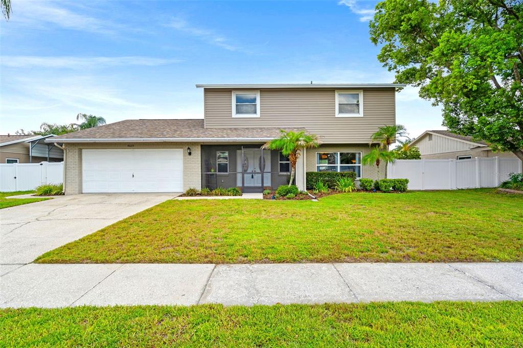 A two-story house with a beige exterior, a two-car garage, and a front lawn — 4029 BELL GRANDE DRIVE, VALRICO, FL