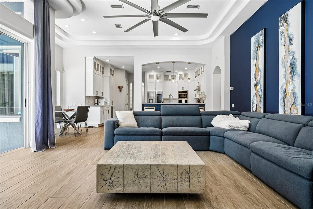 A living room features a blue sectional sofa, a wood block coffee table, and blue walls — 9039 WATERASH LANE N, PINELLAS PARK, FL