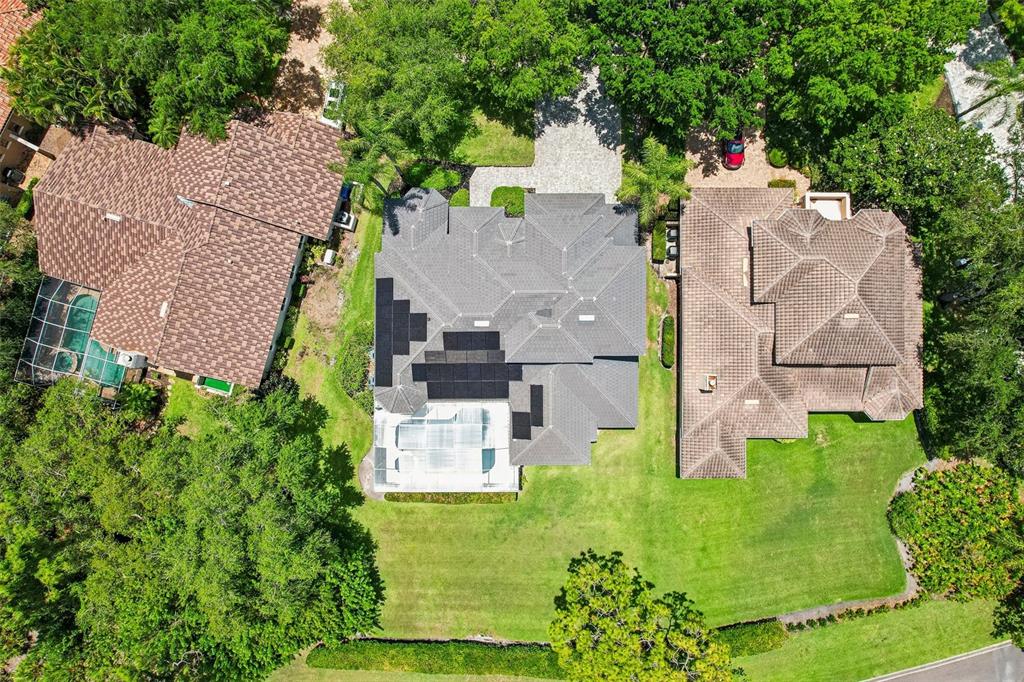 An aerial view shows three houses with tiled roofs surrounded by trees and green lawns — 9039 WATERASH LANE N, PINELLAS PARK, FL