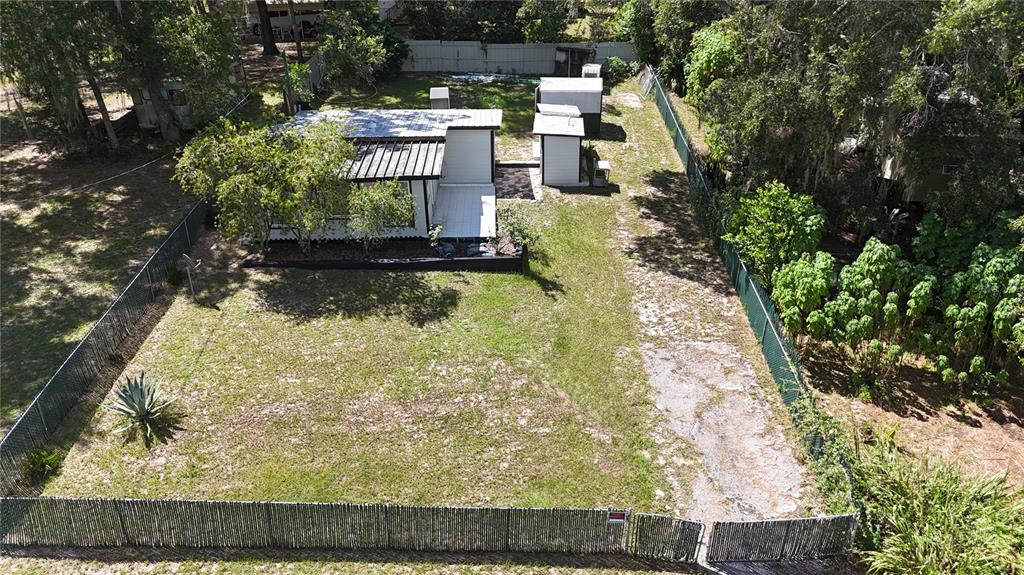 An aerial view shows a small house with a metal roof and two sheds on a lot — 3750 HILLTOP, DUNNELLON, FL