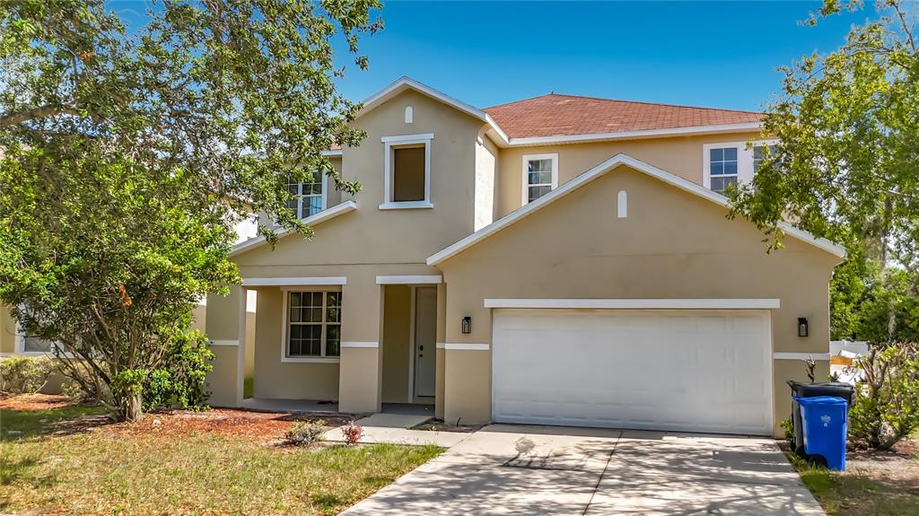 A two-story beige house with a two-car garage and a front porch — 1620 ATLANTIC DRIVE, RUSKIN, FL