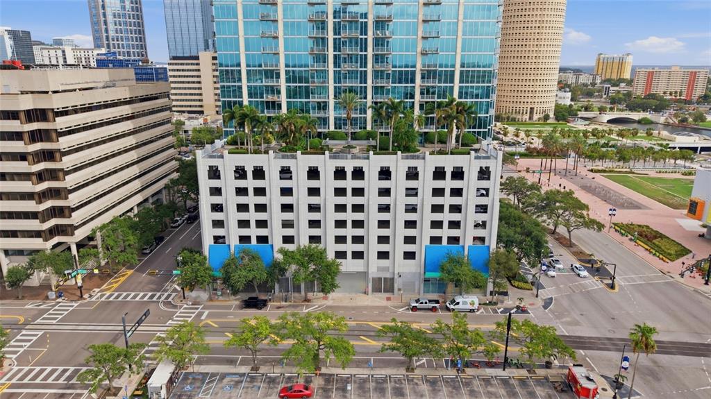 An aerial view shows a parking garage base supporting a modern glass high-rise building — 777 N ASHLEY DRIVE UNIT 2613, TAMPA, FL