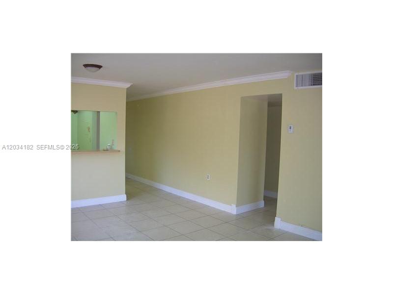 An interior view shows a room with light-colored walls, tile flooring, and a pass-through window — 11261 SW 88 ST # 205H, Miami FL 33176, MIAMI, FL
