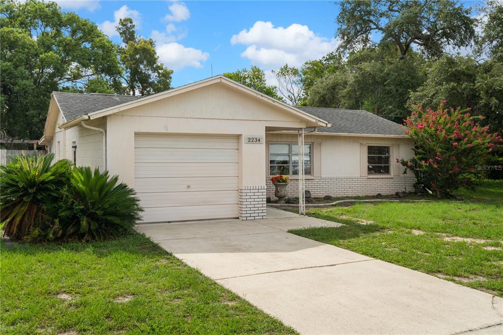 A single-story house with a white exterior, a one-car garage, and a concrete driveway — 2234 MARINER BOULEVARD, SPRING HILL, FL