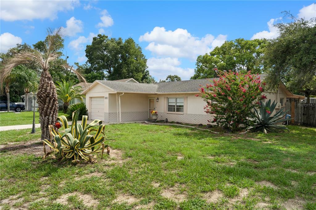 A single-story house with a beige exterior, a one-car garage, and a front yard — 2234 MARINER BOULEVARD, SPRING HILL, FL