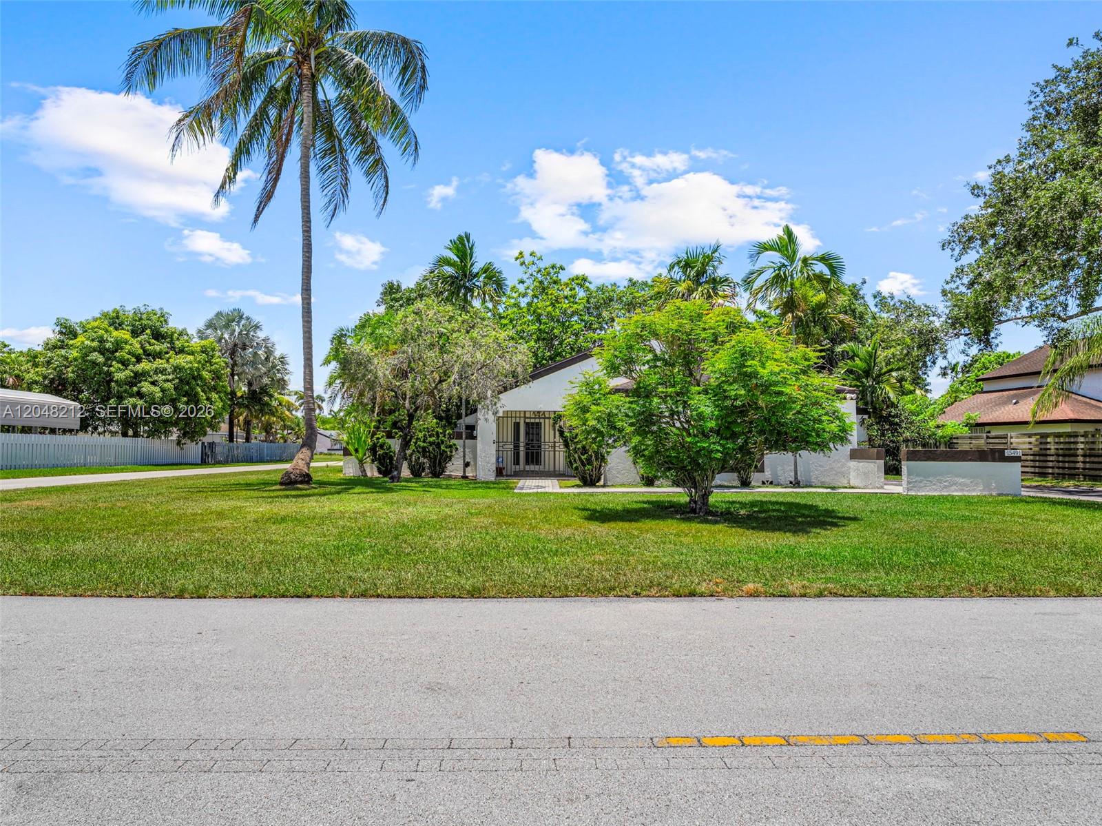 A single-story white house with a palm tree and a large tree in the front yard — 15491 SW 153rd St, Miami FL 33187, MIAMI, FL
