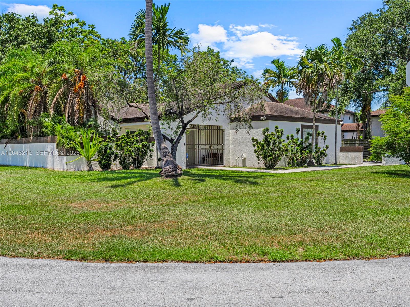 A single-story white house with a brown roof sits behind a large grassy lawn — 15491 SW 153rd St, Miami FL 33187, MIAMI, FL