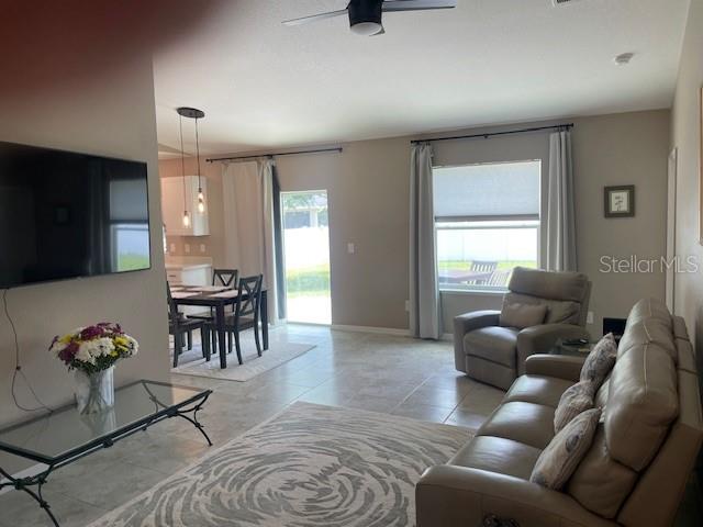 A living room features a leather sofa, a recliner, a glass coffee table, and dining area — 2966 BAY CITY TERRACE, NORTH PORT, FL