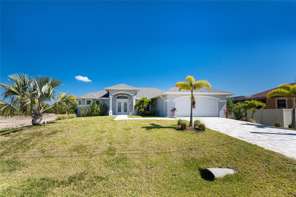 A single-story house with a gray exterior, a two-car garage, and a paved driveway — 10392 RAINSVILLE STREET, PORT CHARLOTTE, FL