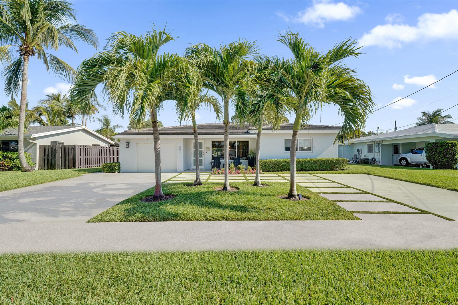A single-story house with a white exterior, a paved driveway, and four palm trees — 381 SE 3rd Street, Pompano Beach FL 33060, POMPANO BEACH, FL
