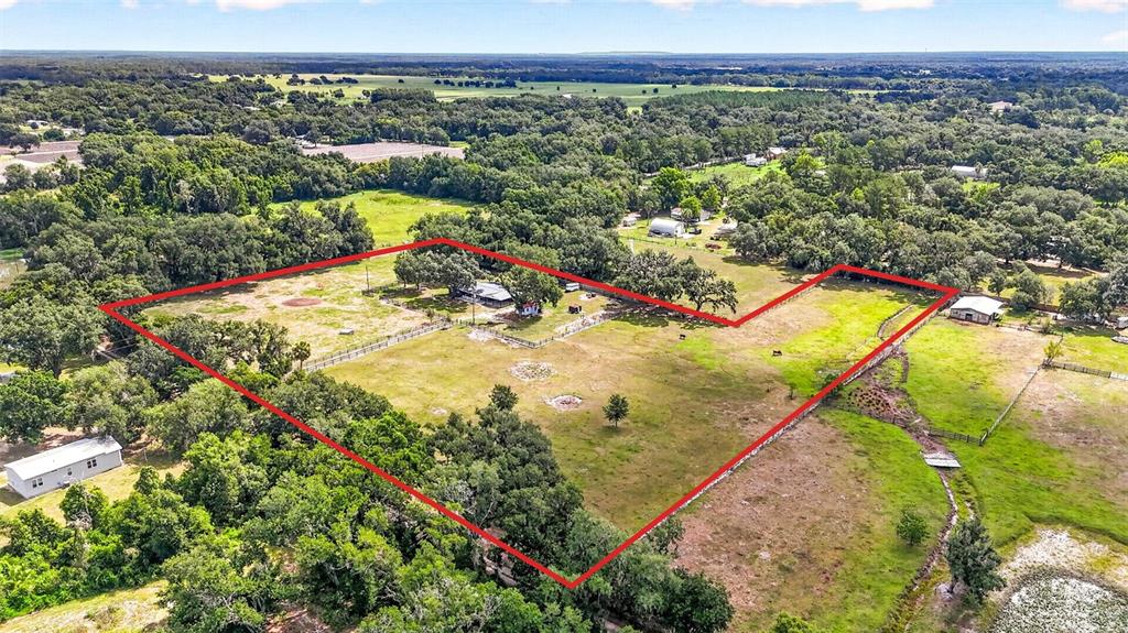 An aerial view shows a large, fenced-in grassy lot with a house and trees — 5702 TINDALE ROAD, PLANT CITY, FL