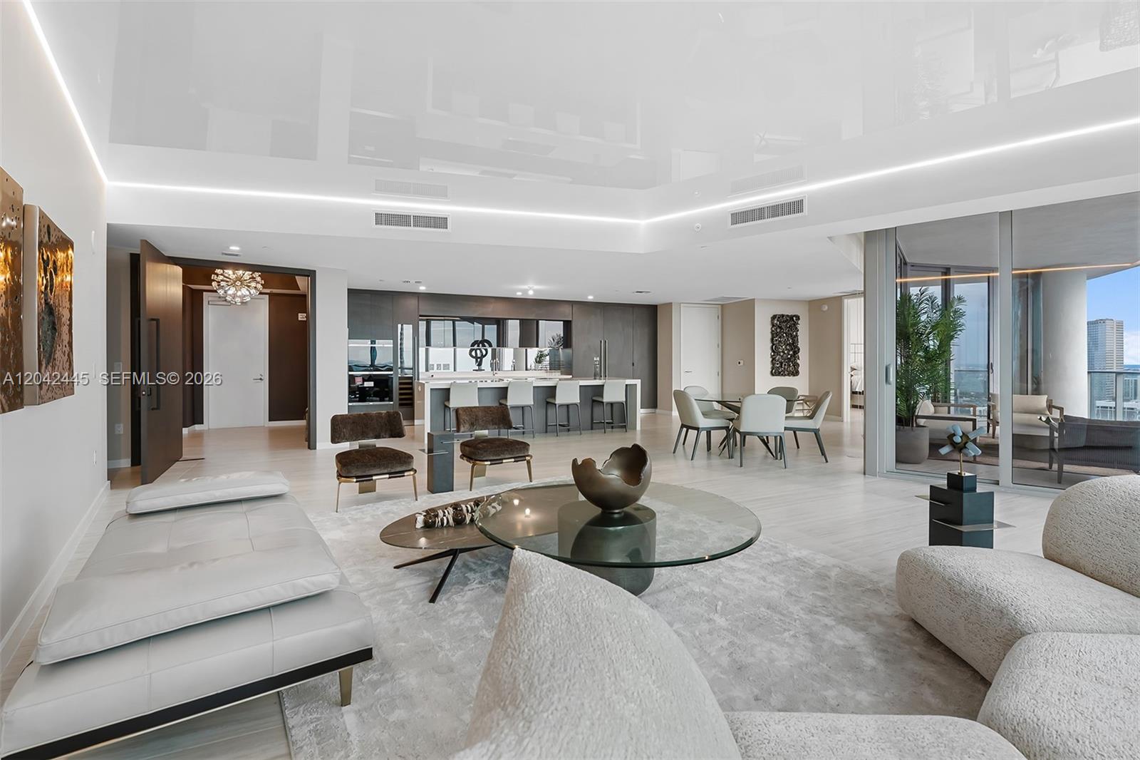 A modern open-concept living area features a kitchen, dining space, and balcony with city views — 851 NE 1st Ave # 4912, Miami FL 33132, MIAMI, FL