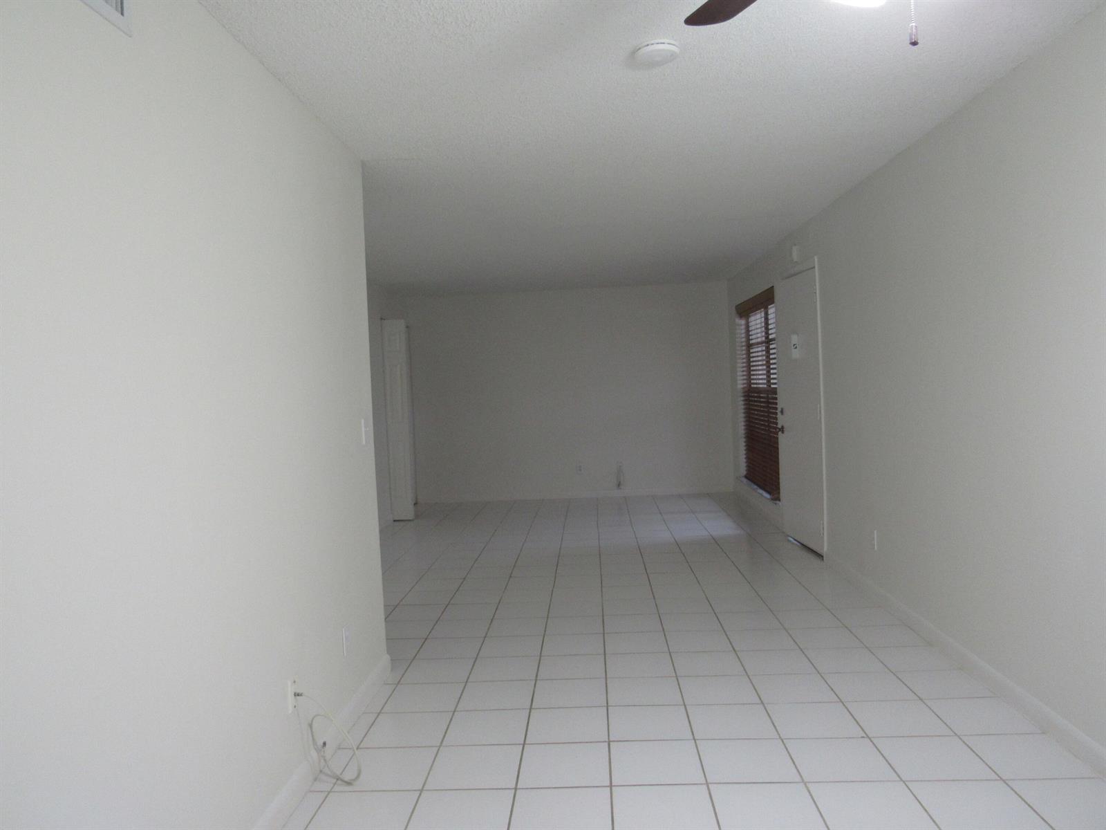 An empty room with white walls, white tile flooring, and a window with blinds — 2110 SE Edler Drive, Stuart FL 34994, STUART, FL