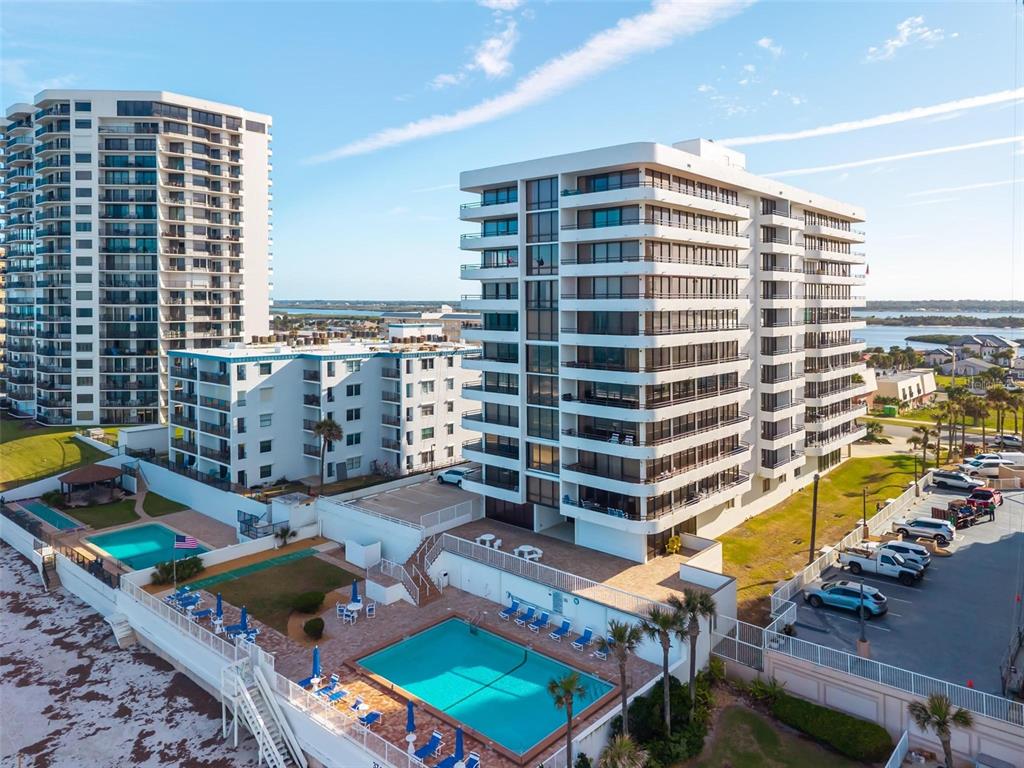 An aerial view of two high-rise apartment buildings with swimming pools and a parking lot — 3743 S ATLANTIC AVENUE UNIT 7A00, DAYTONA BEACH, FL