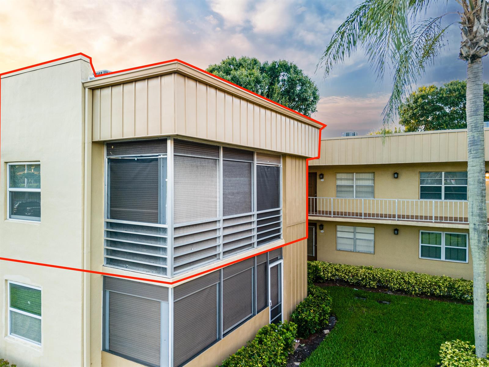 An exterior view of a two-story apartment building with screened-in balconies and tan siding — 509 Capri # 509, Delray Beach FL 33484, DELRAY BEACH, FL