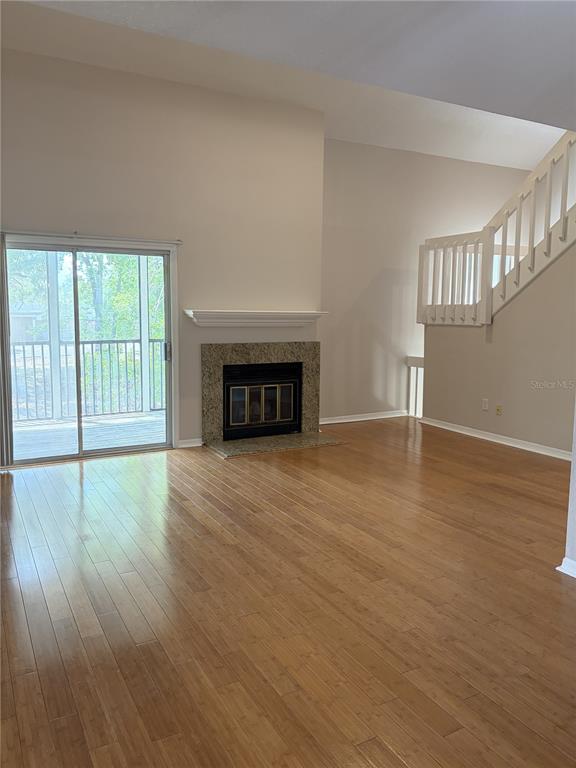 A living room with light wood flooring, a fireplace, and a staircase — 3156 VALLEY OAKS DRIVE UNIT 614, TAMPA, FL