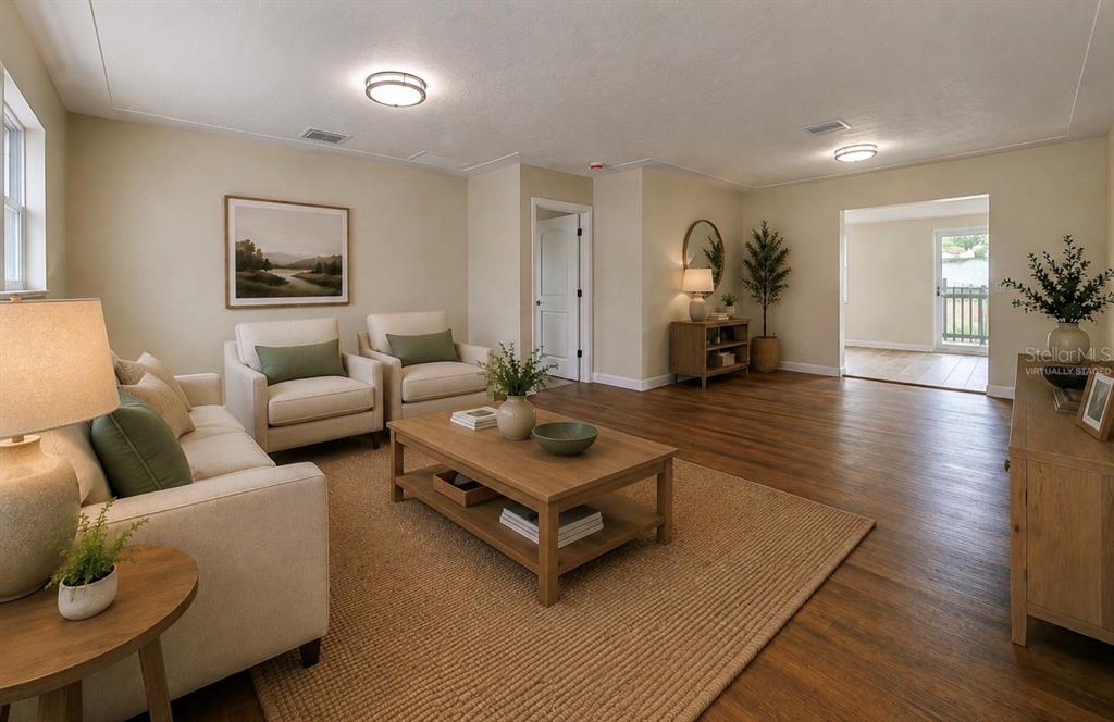 A living room with wood-look flooring, a beige sofa, two armchairs, and a coffee table — 5546 113TH STREET, SEMINOLE, FL