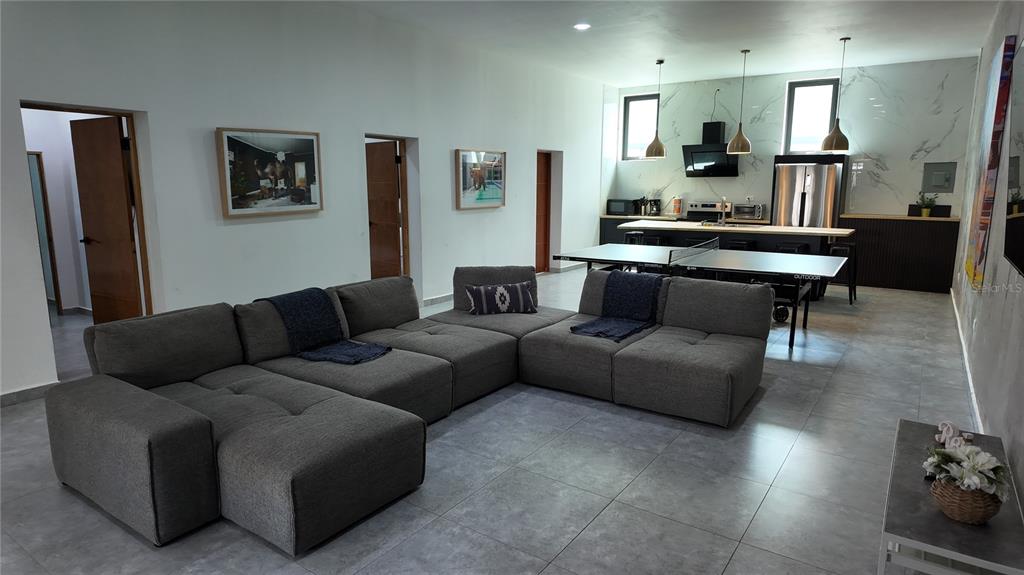 A modern open-concept living room and kitchen feature gray tile floors and a sectional sofa — 73 CALLE TAPIA UNIT 5, SAN JUAN, PR