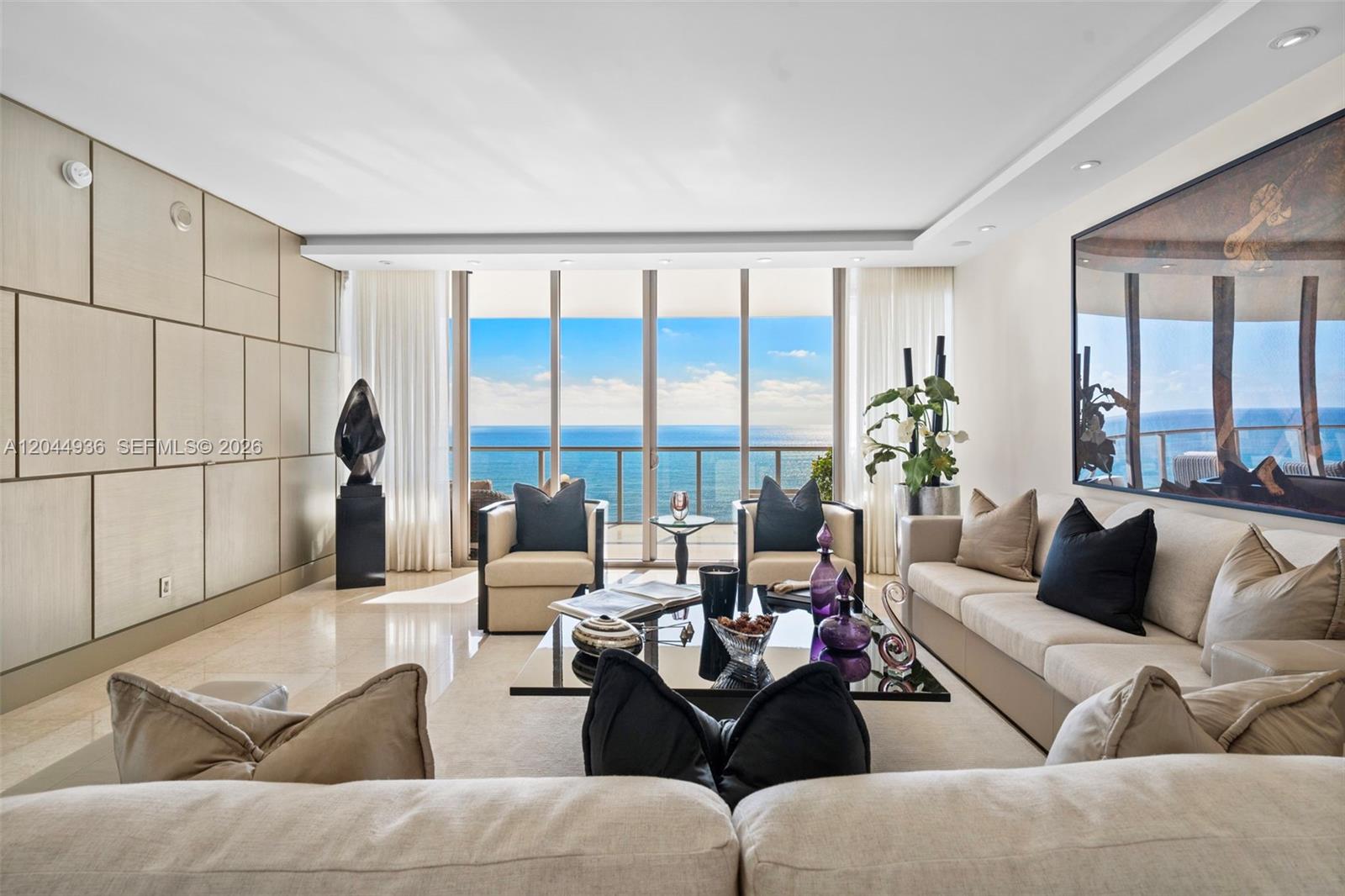 A modern living room features a beige sofa, two armchairs, and floor-to-ceiling ocean views — 9705 Collins Ave # 1402N, Bal Harbour FL 33154, BAL HARBOUR, FL