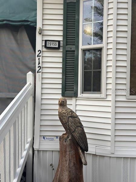 A wooden eagle sculpture stands in front of a white vinyl-sided home exterior — 25155 NE 142ND LANE UNIT 212, FORT MC COY, FL