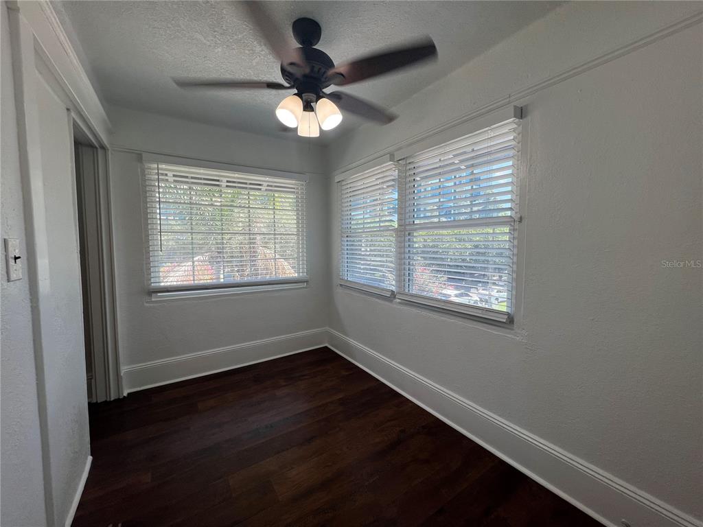 A small room features dark wood flooring, white walls, and a ceiling fan — 510 E JACKSON ST UNIT 7, ORLANDO, FL