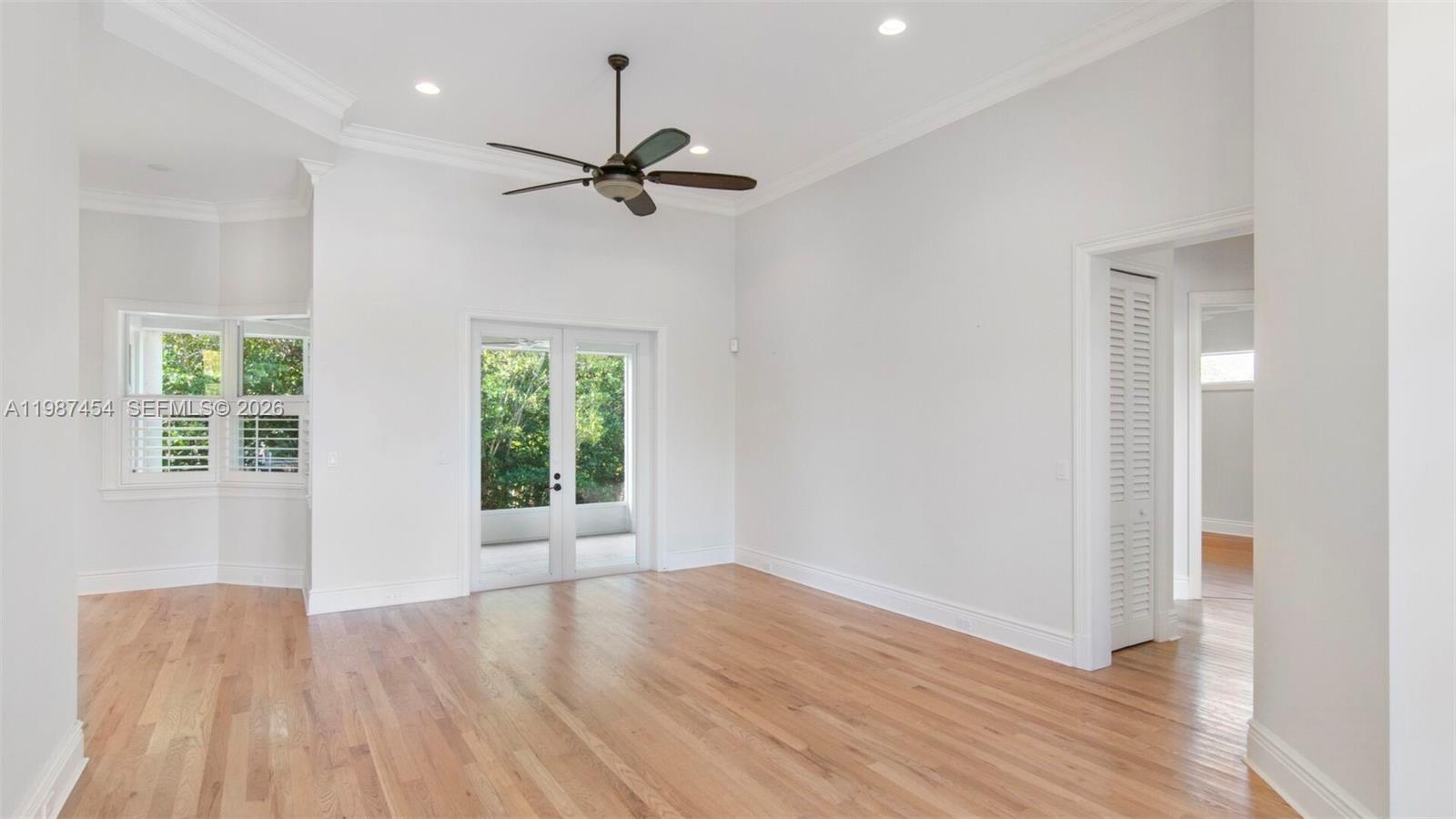 An empty room with hardwood floors, a ceiling fan, and glass doors leading outside — 2135 Island Dr, Vero Beach FL 32963, VERO BEACH, FL