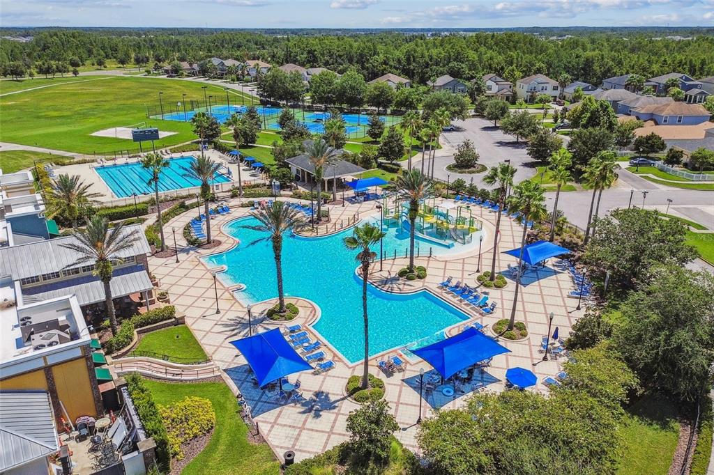 An aerial view of a community pool complex with tennis courts and surrounding residential homes — 7635 PAINTED SKY PLACE, LAND O LAKES, FL