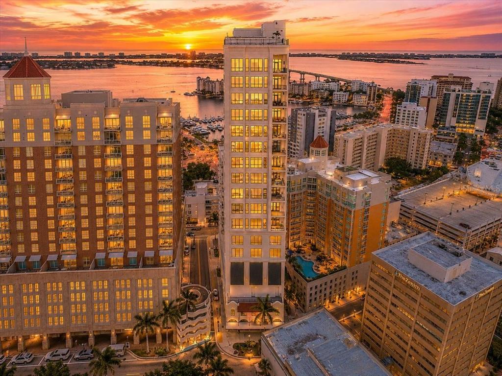 An elevated view of a waterfront marina with multi-story apartment buildings and a bridge — 33 S PALM AVENUE UNIT 901, SARASOTA, FL